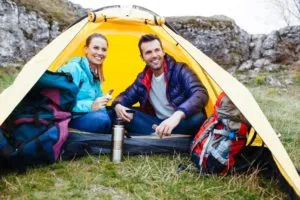 Couple sitting in a tent. Camping near the rocks